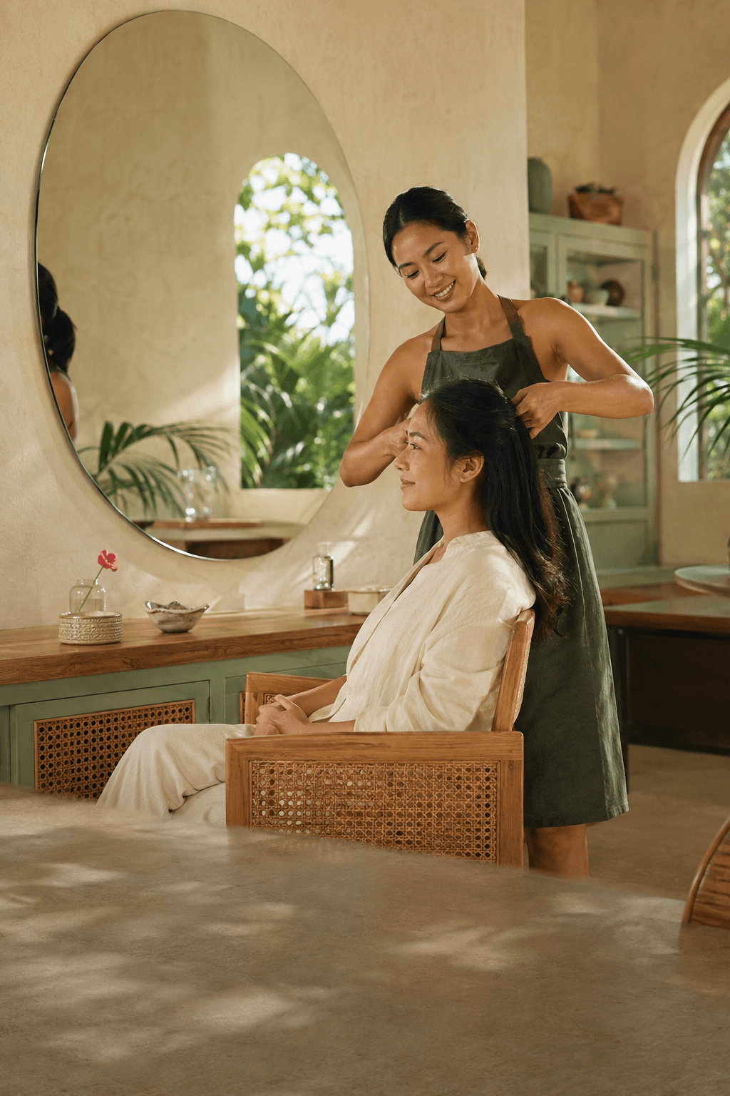 Seorang stylist melayani pelanggan di salon bernuansa Bali dengan cahaya alami